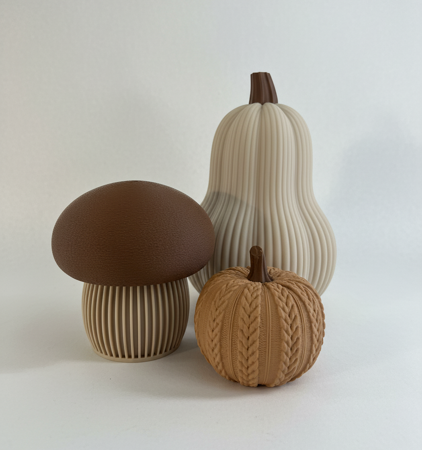 A brown-topped mushroom, a tall ribbed gourd, and a small cable-knit textured pumpkin in neutral and brown tones. Modern autumn trio set.